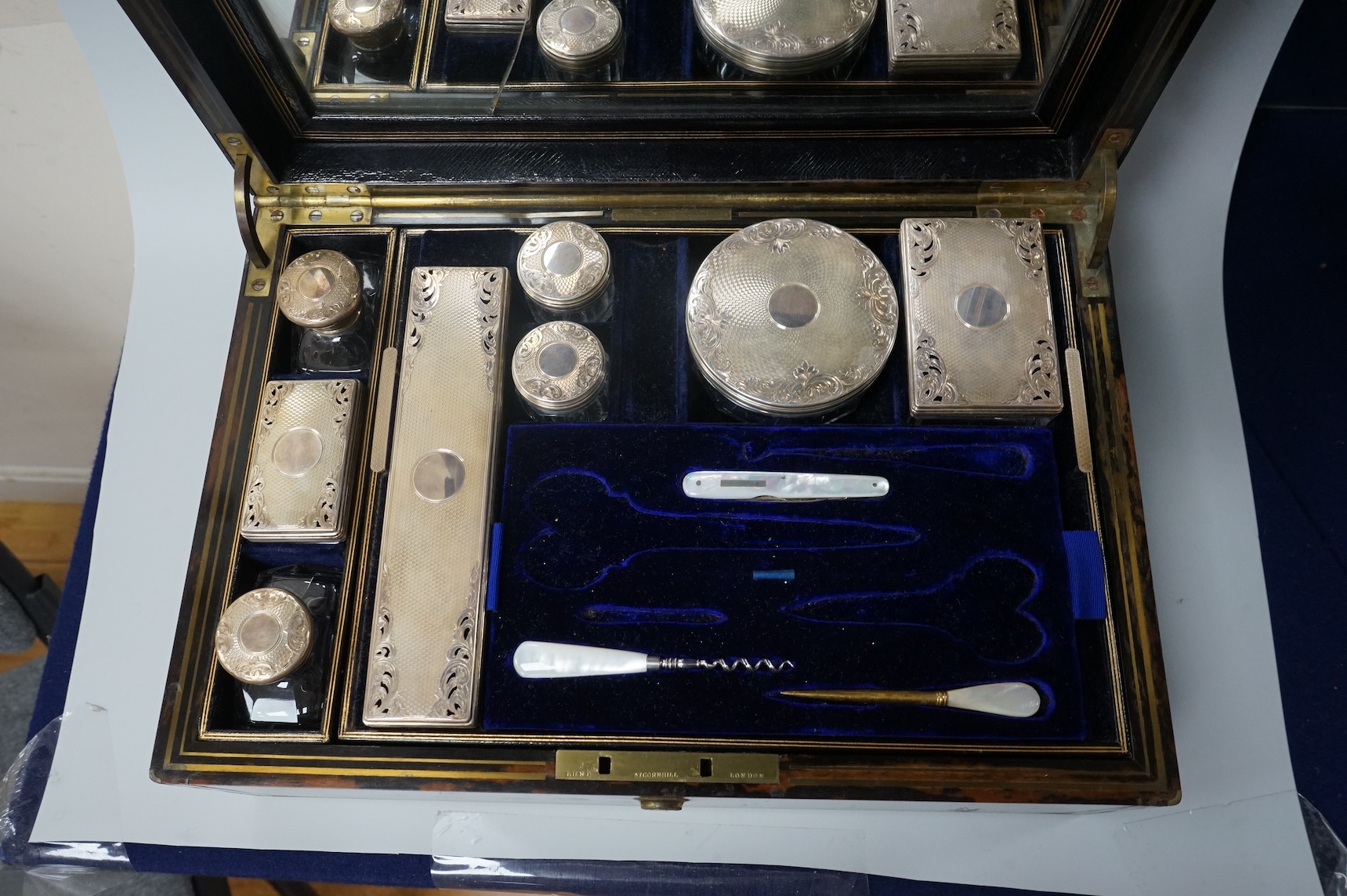 A Victorian brass mounted coromandel wood toilet box by Lund, 57 Cornhill, London, containing eight silver mounted glass toilet jars, six hallmarked for Thomas Johnson I, London, 1865 and three associated? mother of pear